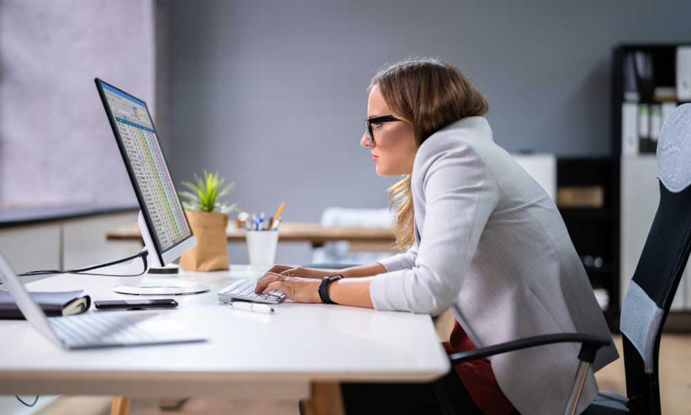 Una mujer en oficina con mala postura